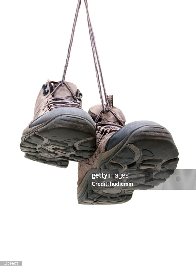 Hiking boots hanging isolated on white background