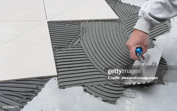 person scrapes concrete at a construction site - 磁磚地板 個照片及圖片檔