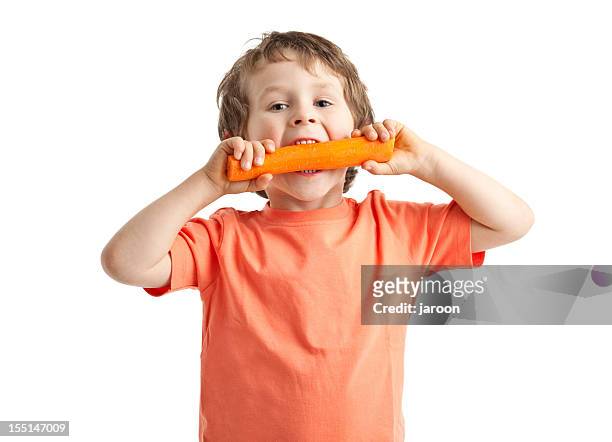 small boy eating carrot - carrot isolated stock pictures, royalty-free photos & images