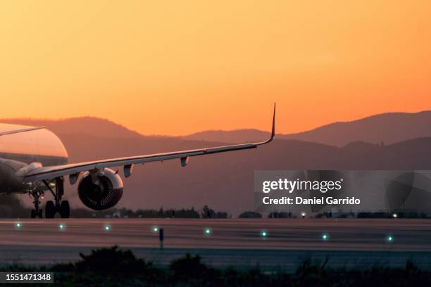 imminent takeoff, rear view of the plane on the runway with a beautiful sunset color, next destination concepts - airplane runway stockfoto's en -beelden