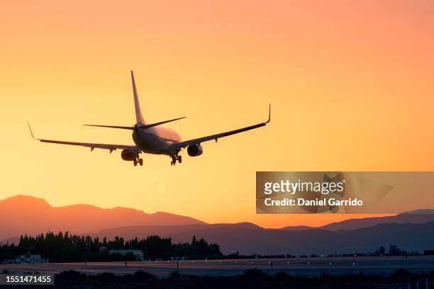 epic landing with the sunset and the mountains, plane landing beneath a breathtaking sunset, sunset landing - plane landing stock-fotos und bilder