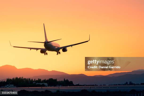 epic landing with the sunset and the mountains, plane landing beneath a breathtaking sunset, sunset landing - voler photos et images de collection