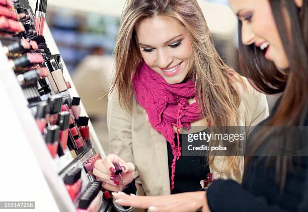 girl testing and  purchases cosmetics in the beauty shop - applying makeup with brush stock pictures, royalty-free photos & images