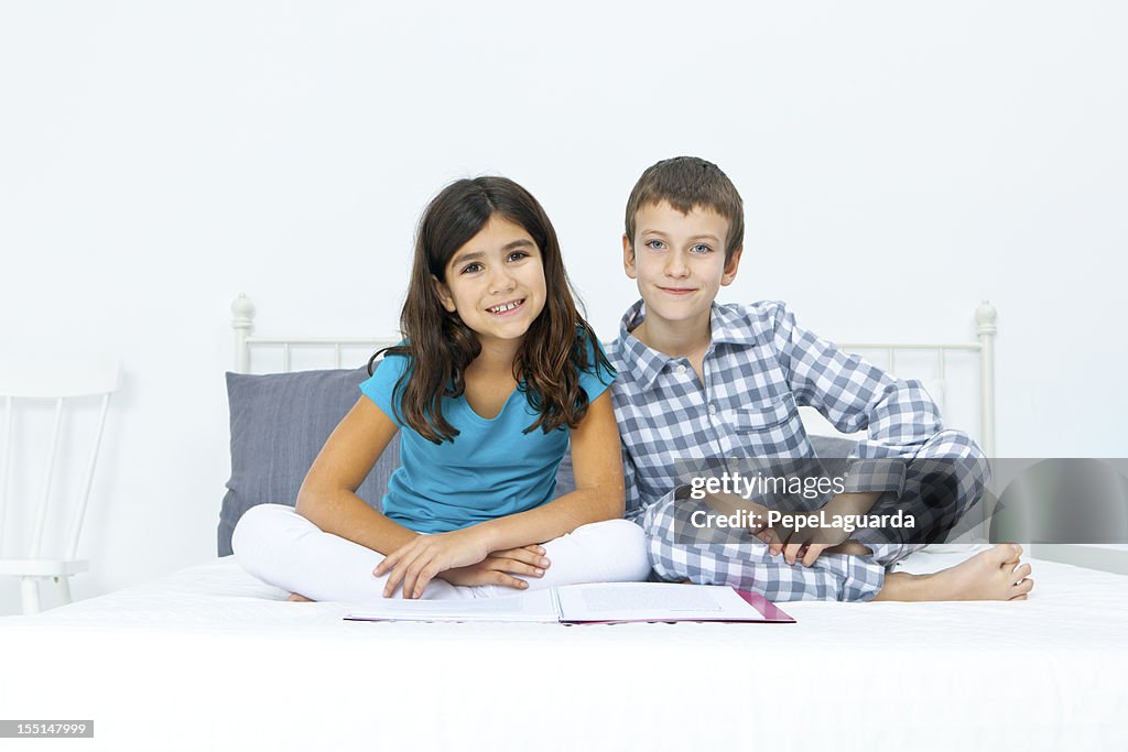 Boy and girl reading on bed