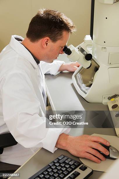 scientist using an electron microscope - elektronenmicroscopisch-beeld stockfoto's en -beelden