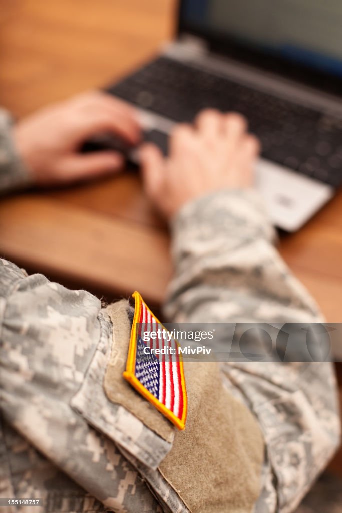 American soldier writing on a laptop