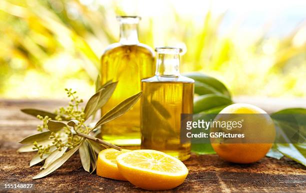 massage oil bottles with lemons and olive branch - body care and beauty stock pictures, royalty-free photos & images