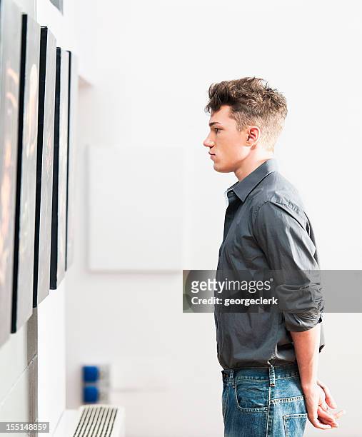 looking at art gallery pictures - man stand stockfoto's en -beelden