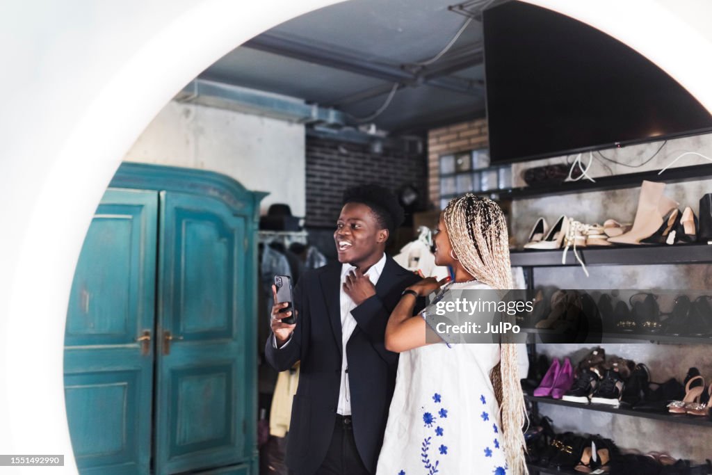 Young adult black couple making selfie at clothing store