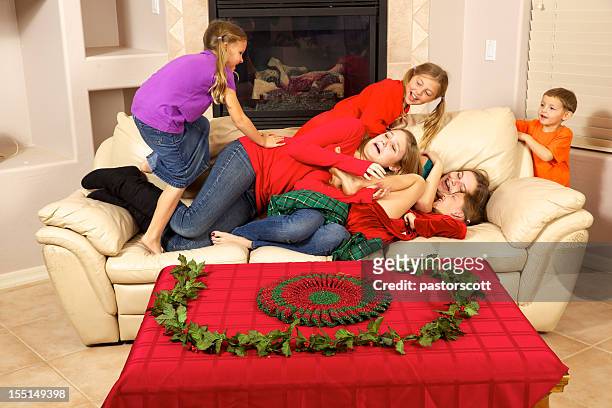 christmas teens and children with fun and problems on couch - girls wrestling stock pictures, royalty-free photos & images