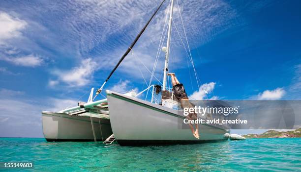 vacaciones tropicales: man diving en barco de vela - catamaran caribbean fotografías e imágenes de stock