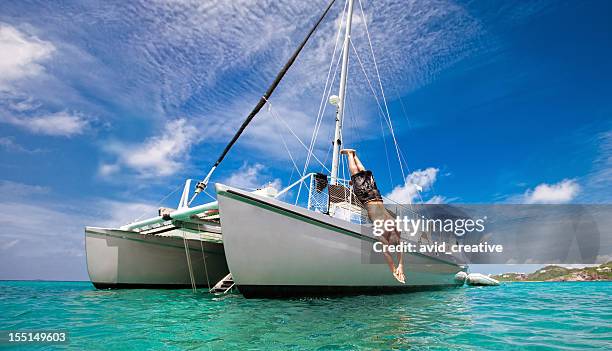 vacances sous les tropiques: homme de plongée en bateau à voile - jumping of boat photos et images de collection