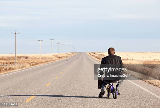 businessman commuting on tiny bicycle - patient journey stock pictures, royalty-free photos & images