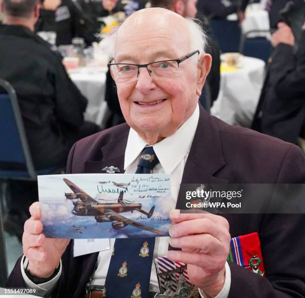 World War Two veteran Rust Waugham holds up a picture of the Lancaster bomber he flew in World War Two, which King Charles III autographed today on a...