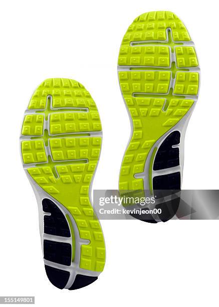 yellow and black treaded soles of athletic shoes - schoenzool stockfoto's en -beelden