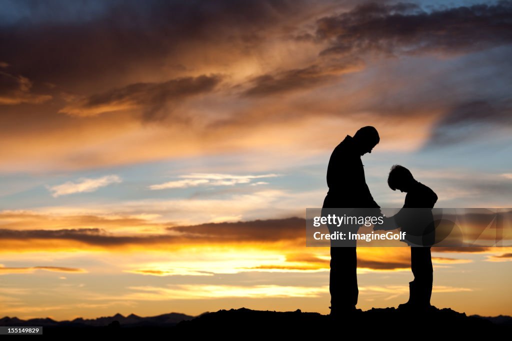 Silhouette of Father and Son Praying