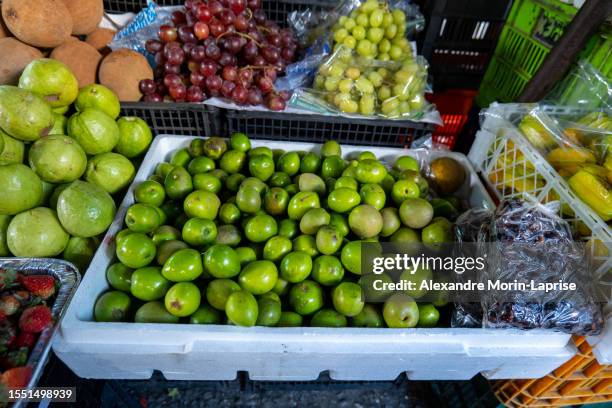 bunch of green jocotes (spondias purpurea) known as ciruela or purple mombin, a fruit native to central america in a foam box on a stall in colorful market mercado mayor - spondias mombin stock pictures, royalty-free photos & images