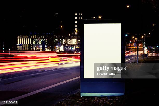 blank advertising billboard on city street at night - city light poster stock pictures, royalty-free photos & images