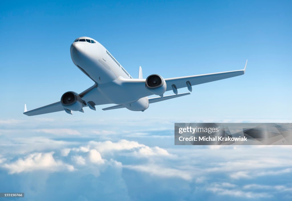 Passenger jet airplane flying above clouds