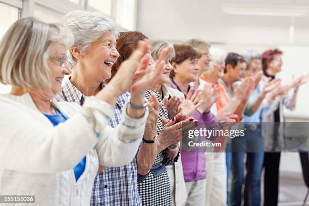 group of senior women applauding - reünie sociaal stockfoto's en -beelden