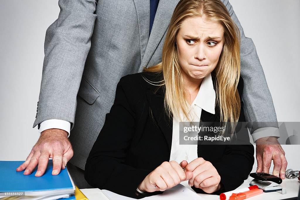 Helpless blonde businesswoman is harassed by threatening businessman