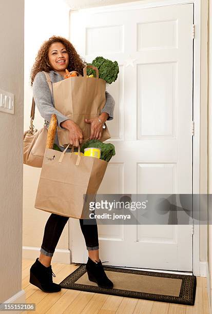 woman coming home with grocery bags - carrying groceries stockfoto's en -beelden