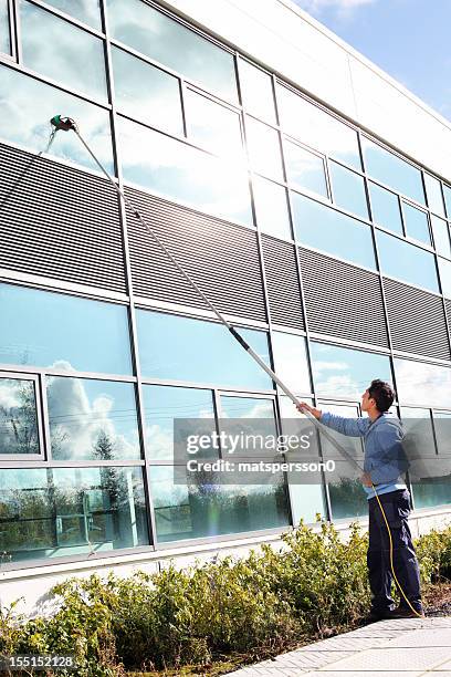 window cleaner using the water fed pole system - window cleaning stock pictures, royalty-free photos & images