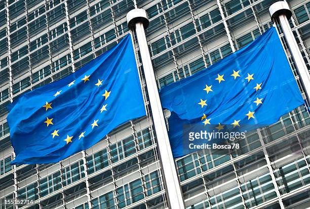 pair of eu flags at european commission, brussels - european commission stock pictures, royalty-free photos & images