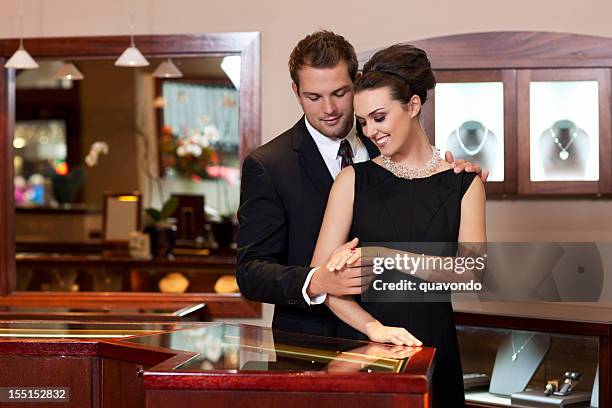 attractive young couple shopping for rings in jewelry store, copyspace - diamond jeweller stock pictures, royalty-free photos & images