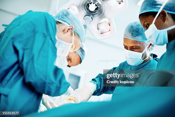 medical team performing de la cirugía - cirugía fotografías e imágenes de stock