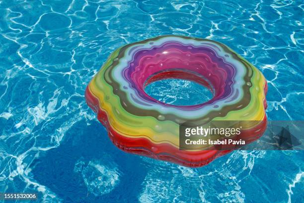 inflatable swim rings floating at swimming pool - month stock pictures, royalty-free photos & images