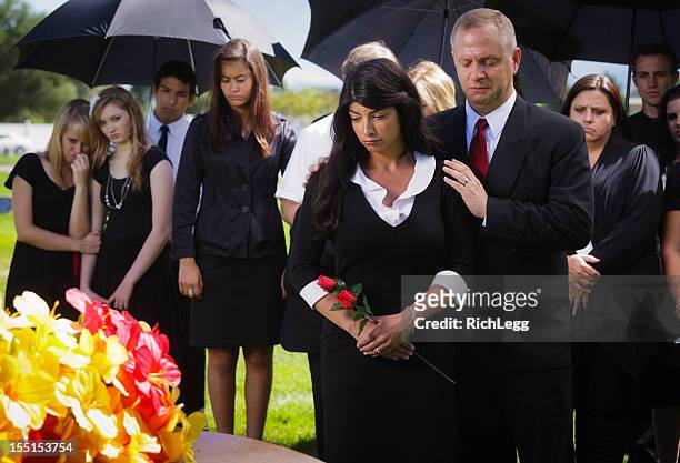 familie bei einer beerdigung - mourning stock-fotos und bilder