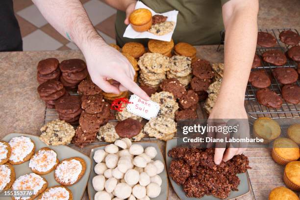 choosing cookies at a bake sale - bake sale stock pictures, royalty-free photos & images