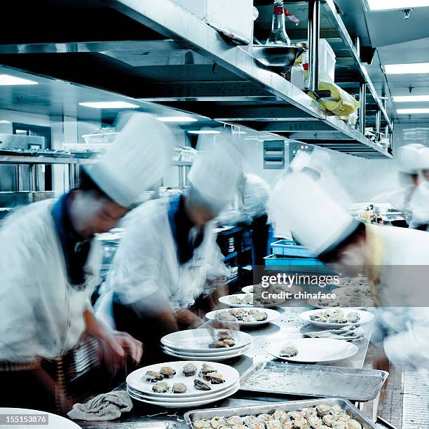 motion chefs  of a restaurant kitchen - crowded kitchen stock pictures, royalty-free photos & images