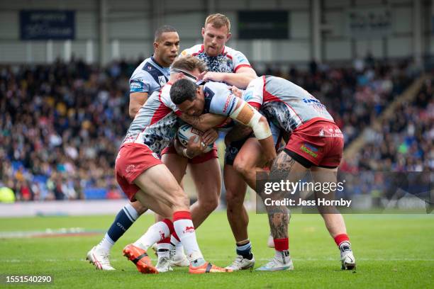 Sione Mata'utia of St.Helens is tackled by Ben Reynolds, Jack Hughes and Zak Hardaker of Leigh Leopards during the Betfred Challenge Cup Semi Final...