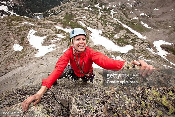 glückliche junge frau, die eine kletter-route in colorado - gebirgskamm stock-fotos und bilder