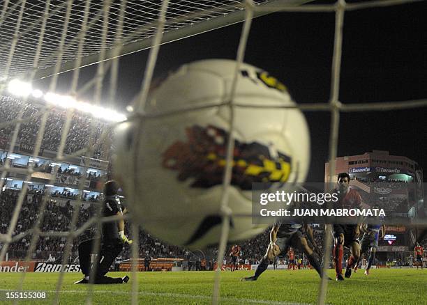 Chile's Universidad Catolica forward Kevin Harbottle strikes next to Argentina's Independiente defender Eduardo Tuzzio to scoring team's second goal...