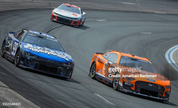 Austin Cindric, driver of the Autotrader Ford, and Daniel Suarez, driver of the SLAM! Foundation Chevrolet, race during the NASCAR Cup Series Crayon...