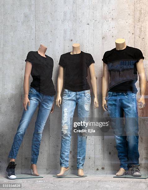 shop window with three mannequins - tshirt jeans stockfoto's en -beelden