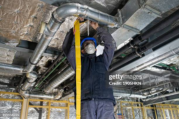 worker wrapping an hvac air duct with foil tape - air ducts stock pictures, royalty-free photos & images