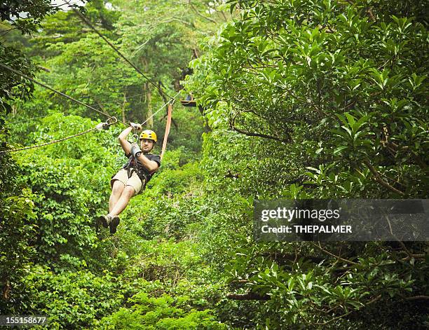 man during a canopy tour costa rica - costa rica zipline stock pictures, royalty-free photos & images