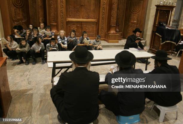 Religious Jews from the Brastlav sect read from the book of Eicha during the annual 9th of Av memorial for the destruction of ancient Jerusalem in...