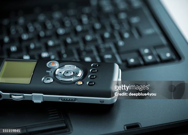 digital voice recorder lying on laptop - tape recorder stock pictures, royalty-free photos & images