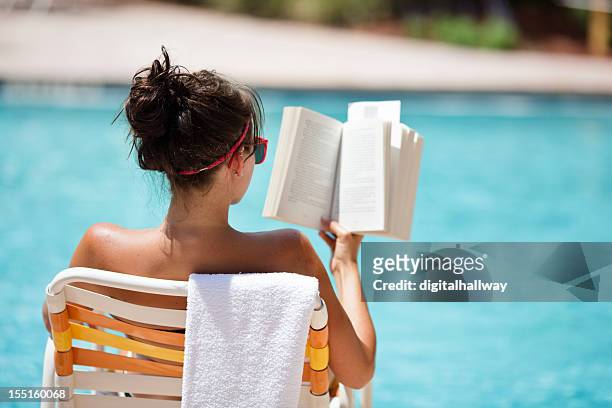 female reading at the pool in the summer - beach towel stockfoto's en -beelden