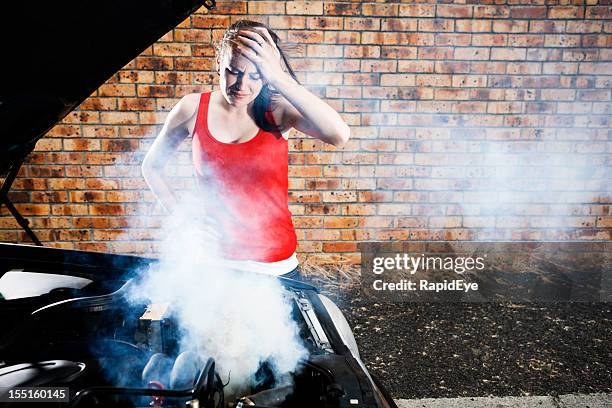 pretty girl looks in despair at engine after car breakdown - overheated stock pictures, royalty-free photos & images