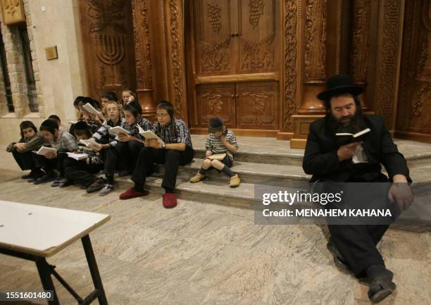 Religious Jews from the Brastlav sect read from the book of Eicha during the annual 9th of Av memorial for the destruction of ancient Jerusalem in...