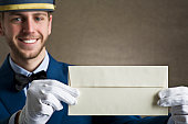 Bellboy holding an envelope as copy space.