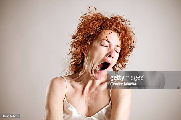 yawning red haired woman in silk shirt - tired bildbanksfoton och bilder
