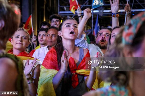 Popular Party supporter reacts to a vote count update giving victory to the Popular Party as she waits outside the Popular Party headquarters. Dozens...