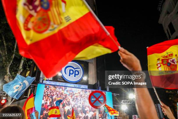The logo of the popular party on the balcony of the headquarters, surrounded by Spanish flags. Dozens of people gather at Calle Génova 13 at the...